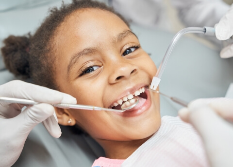 Child receiving a dental checkup and teeth cleaning