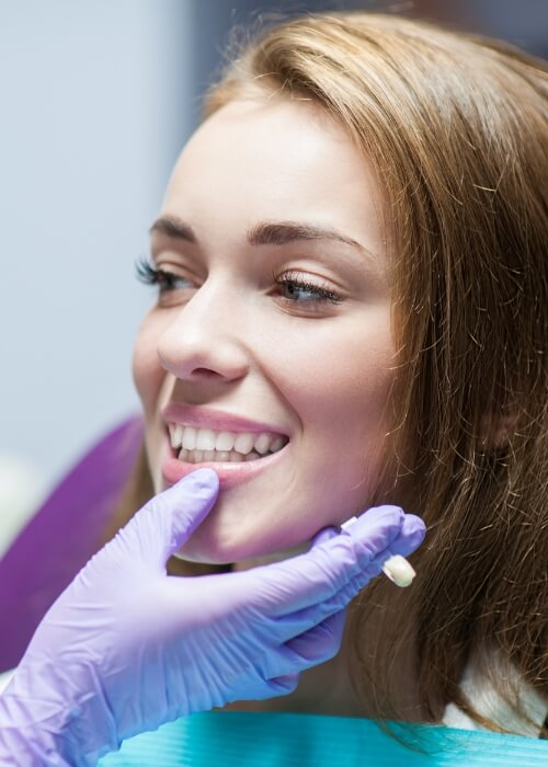 Woman smiling at her dentist after getting dental crowns in Cumming