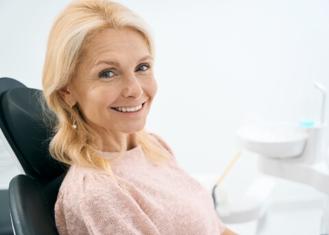 Smiling older woman sitting in dental chair