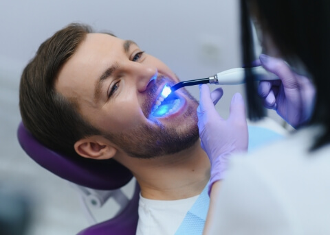 Dental patient having a U V light shone into his mouth