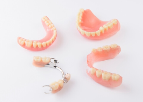 Two full dentures and two partials against white background