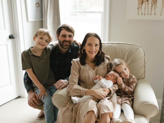 Doctor McTier sitting in her living room with her husband and their three children