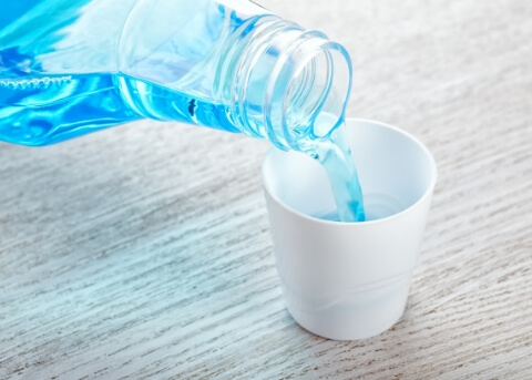 Blue mouthwash being poured into cap