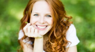 Smiling woman with long curly red hair