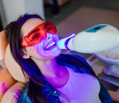 Woman in dental chair getting her teeth whitened