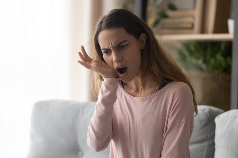 Patient holding their face due to dental emergencies